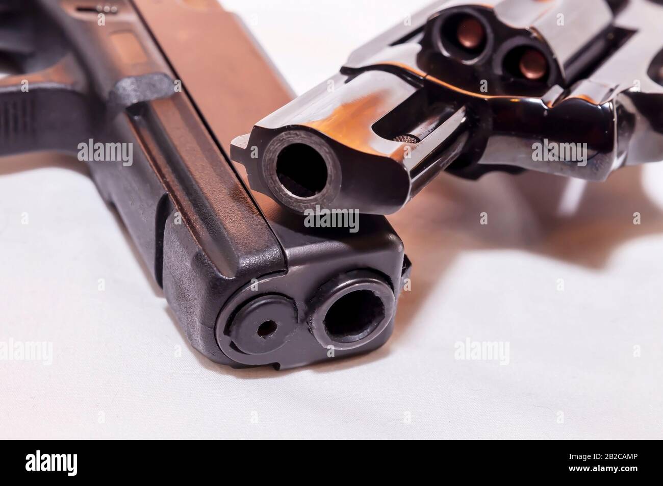 Due pistole, una pistola nera da 40 calibro e una speciale penna nera da 38 giri su sfondo bianco Foto Stock