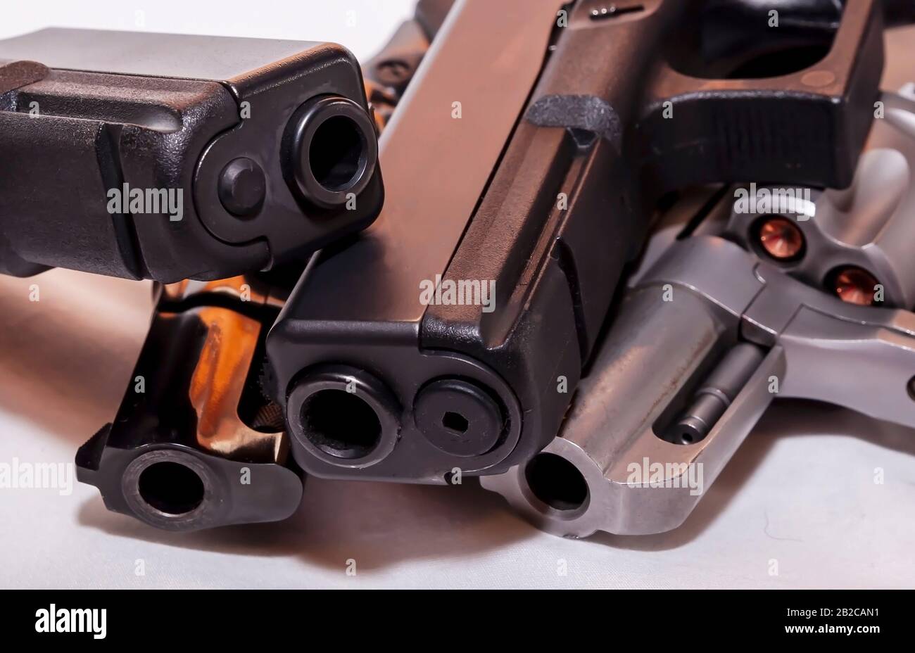 Quattro pistole, due pistole nere a 9mm e un calibro 40 con revolver nero, 38 speciali e una argento, 357 Magnum su sfondo bianco Foto Stock