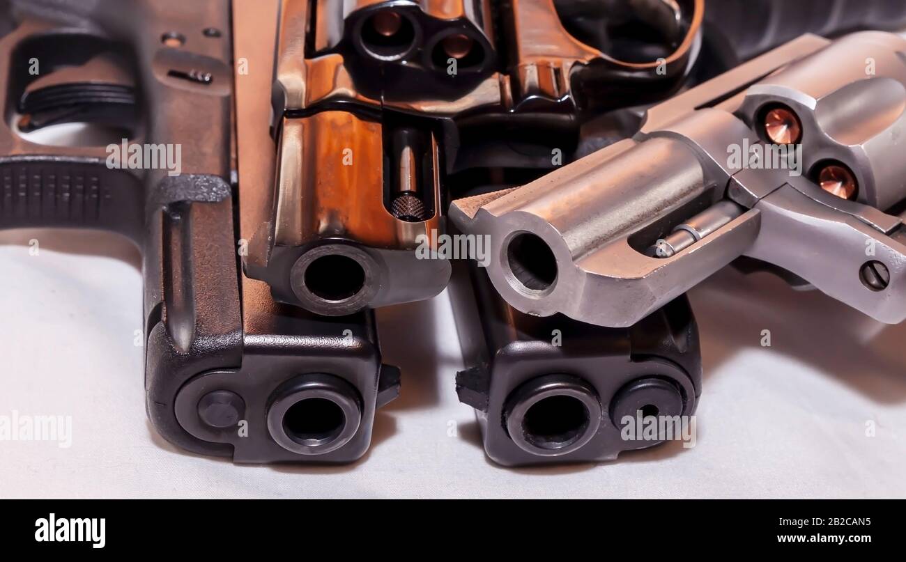 Quattro pistole, due pistole nere a 9mm e un calibro 40 con revolver nero, 38 speciali e una argento, 357 Magnum su sfondo bianco Foto Stock
