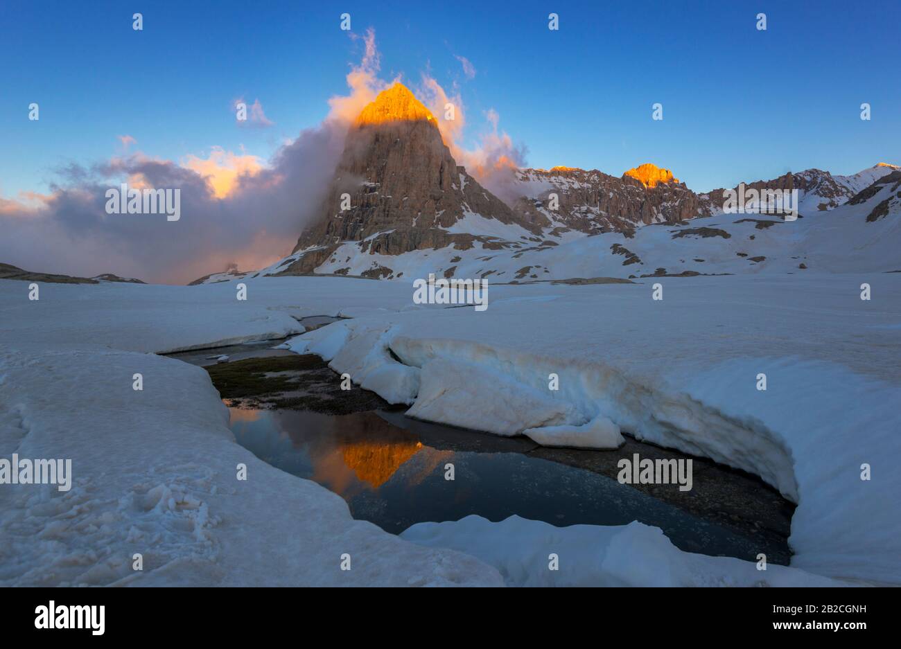 Serata in montagna. Il picco di luce solare si riflette in acqua aperta. Terreno da tavola di Edigol coperto di neve (Aladaglar). Foto Stock