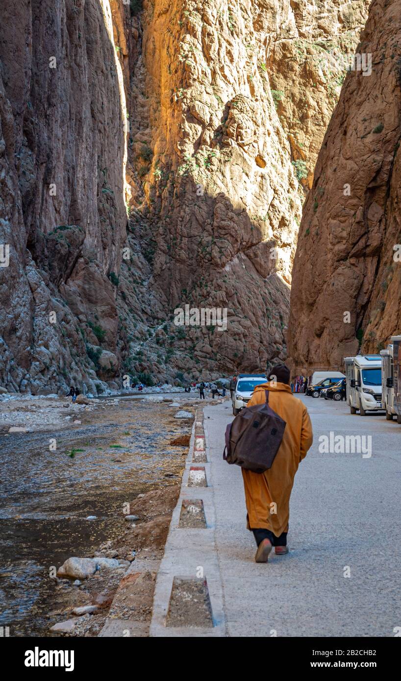 L'uomo solitario che viaggia attraverso le famose gole di Toudgha, alla ricerca di un trasporto che lo porta alla città di Tinghir (Marocco) Foto Stock