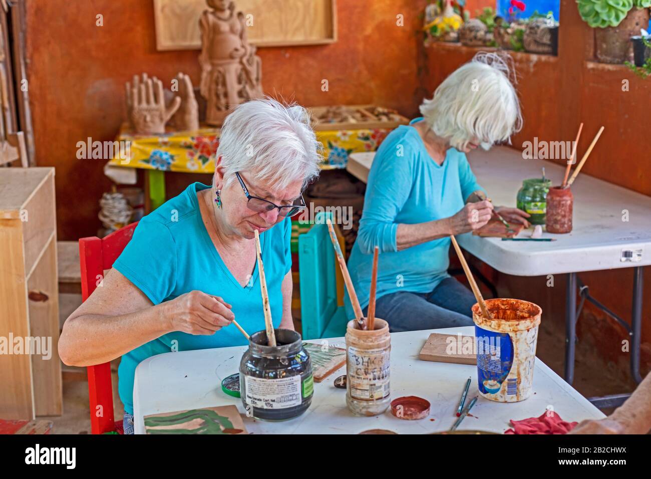Yanhuitlan, Oaxaca, Messico - I Turisti partecipano ad un laboratorio di ceramica nello studio dell'artista di ceramica Manuel Reyes. Foto Stock