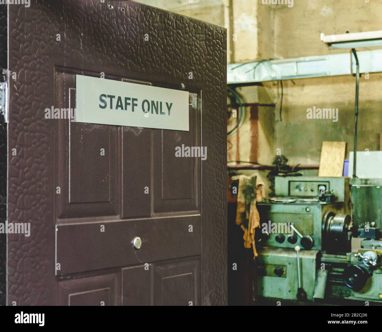 Porta aperta con solo il personale di bordo che conduce alla sala officina di riparazione auto Foto Stock