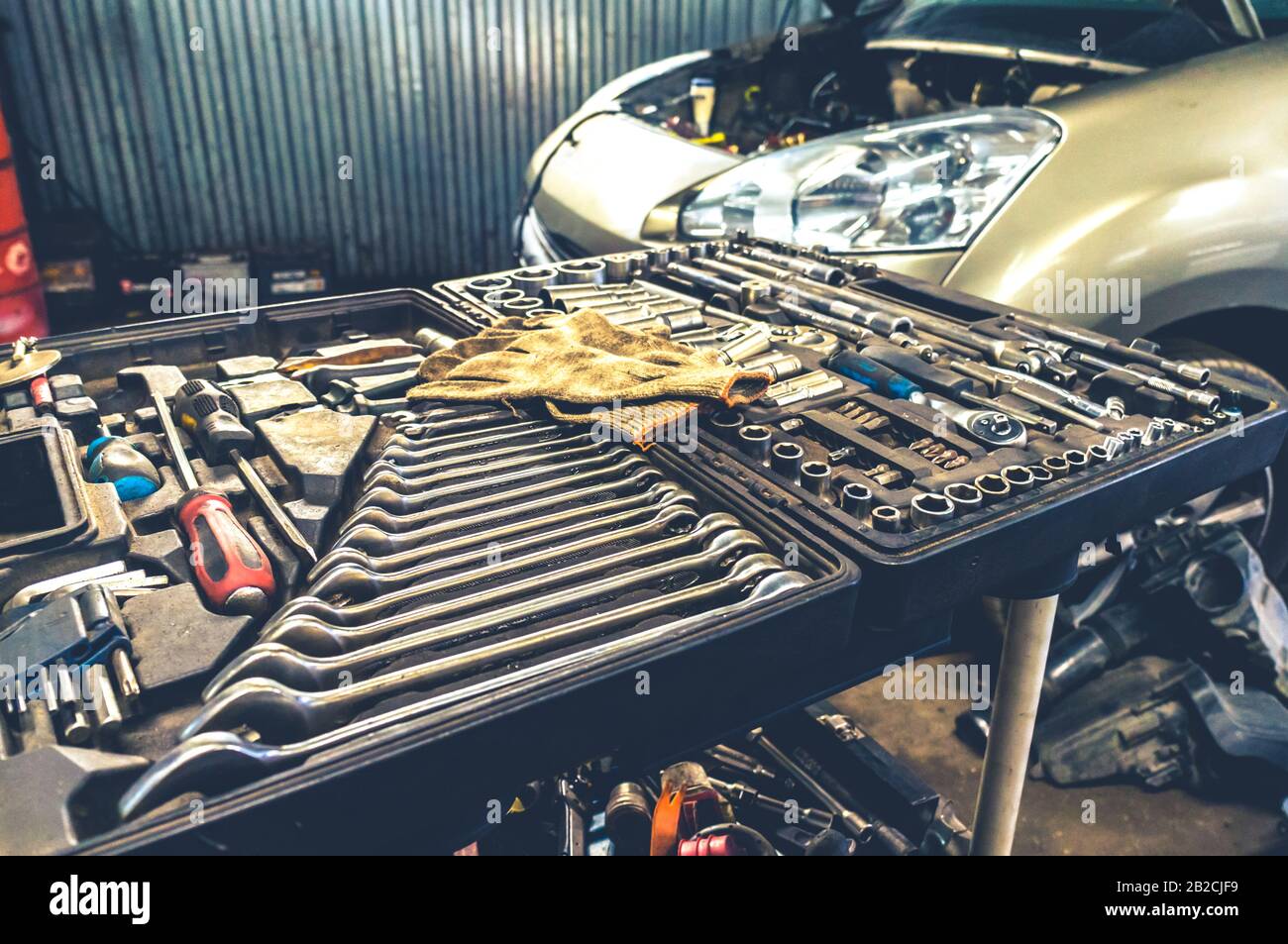 Fissaggio di utensili meccanici a mano in una scatola aperta presso l'officina di riparazione auto in interni Foto Stock