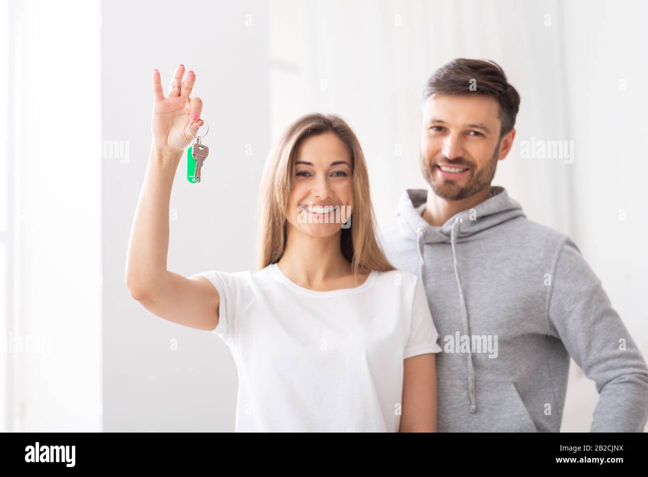 Coppia sposata felice che tiene le chiavi dalla nuova dimora Foto Stock