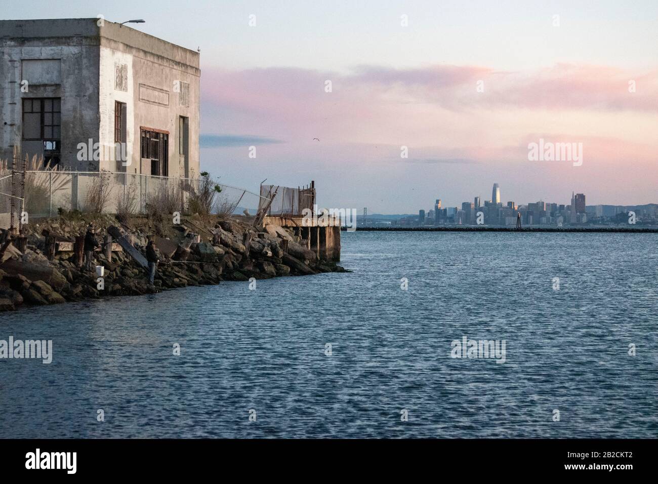 Un paio di pescatori pesano a Point Richmond con San Francisco in lontananza. Foto Stock