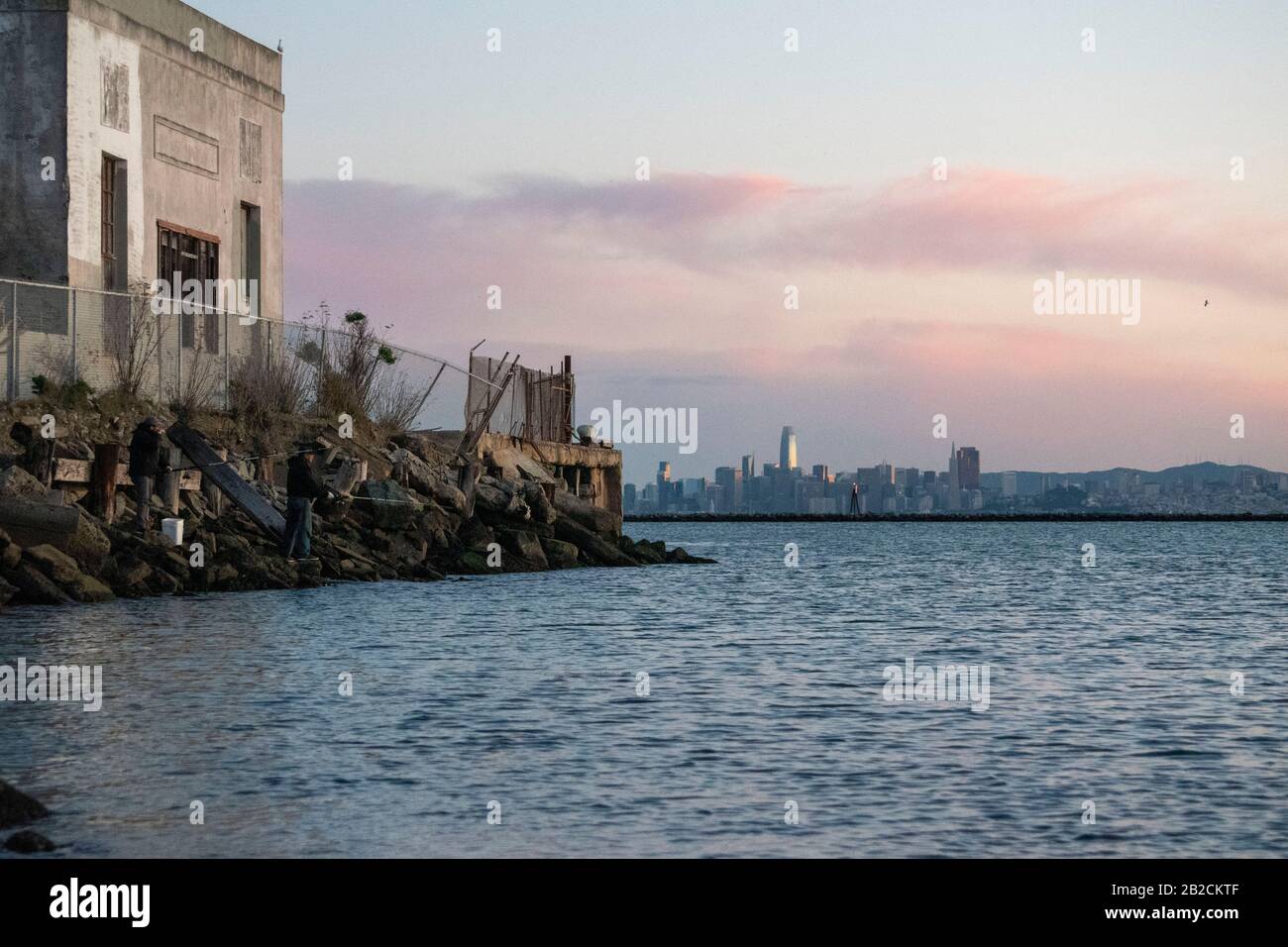 Un paio di pescatori pesano a Point Richmond con San Francisco in lontananza. Foto Stock