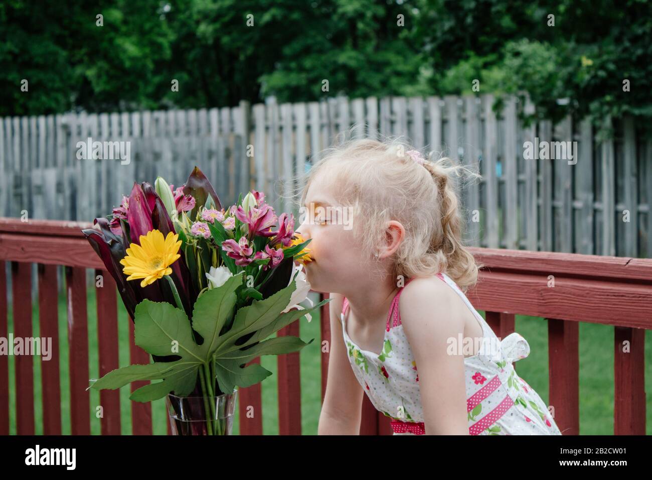 Ragazza giovane in abito Colorato Che Odorano bouquet di fiori in Springtime08 Foto Stock