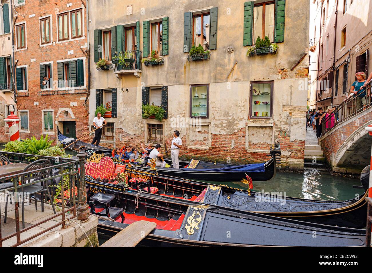 Venezia, ITALIA - 26 GIUGNO 2014: I turisti viaggiano su gondole al canale di Venezia, Italia . Il giro in gondola è l'attività turistica più popolare di Venezia. Foto Stock