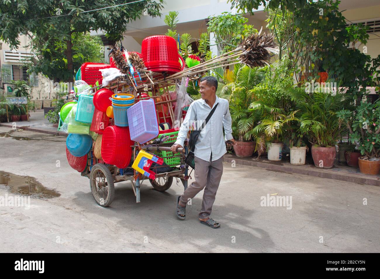 Commercio locale in Cambogia - l'uomo che vende e compra i beni di plastica Foto Stock