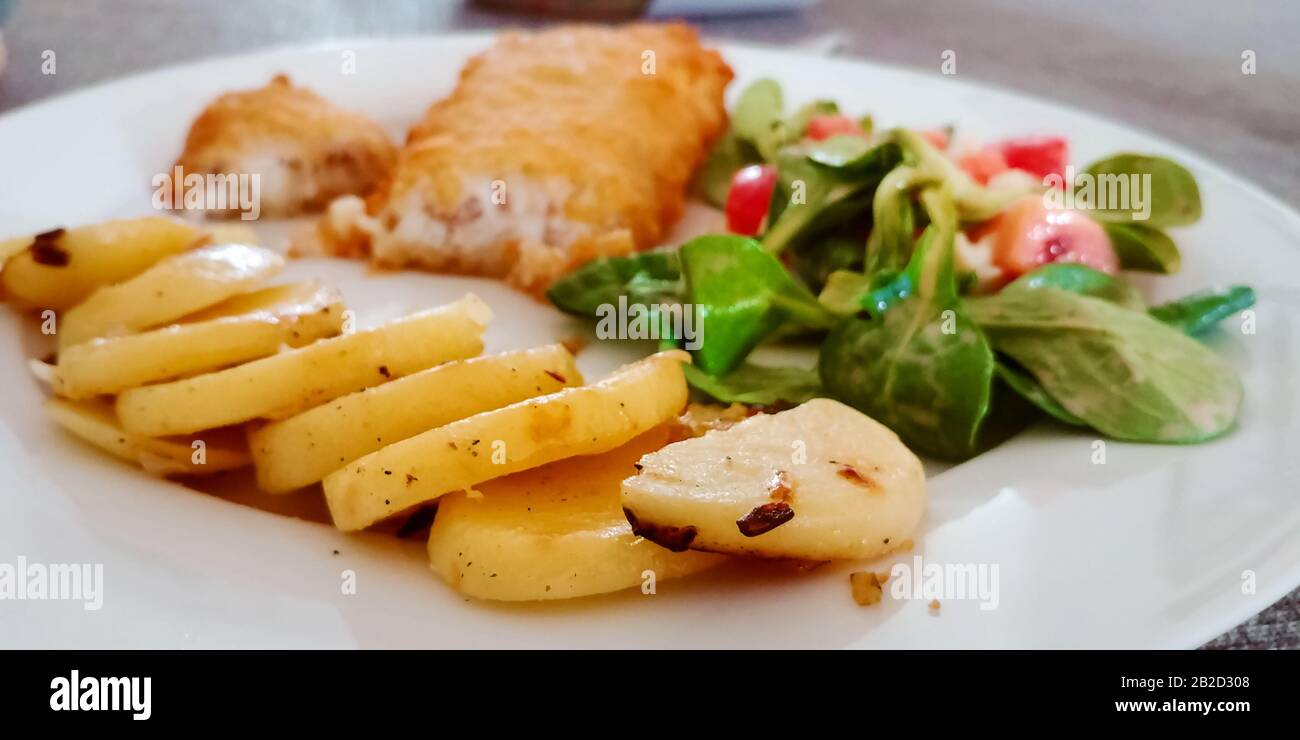 Pasto tradizionale con patate, pesce fritto e insalata. Messa a fuoco selettiva. Foto Stock