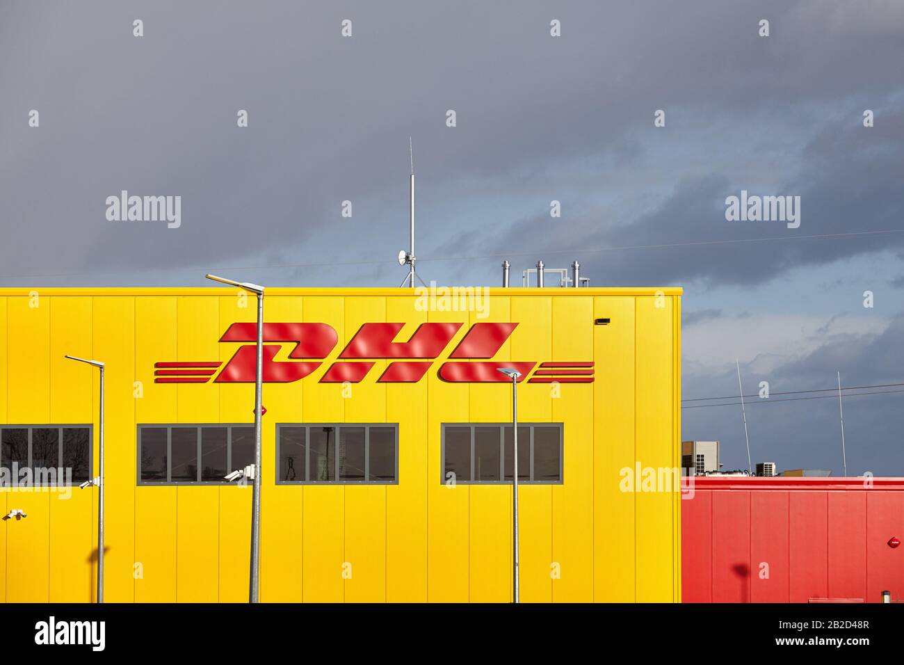 Przeclaw, Polonia - 28 febbraio 2020: DHL Parcel Customer Service Point con cielo tempestoso in background. L'azienda opera in oltre 220 paesi e. Foto Stock
