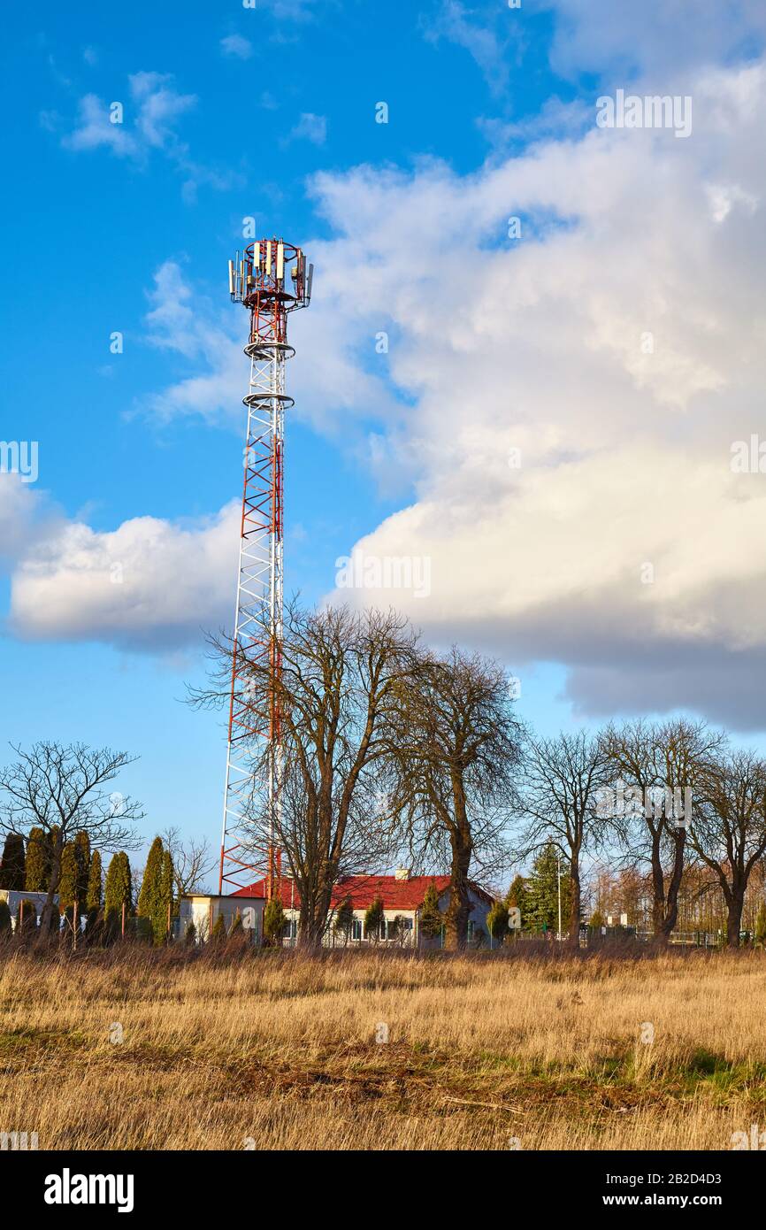 Paesaggio rurale con torre di telecomunicazioni con antenne. Foto Stock