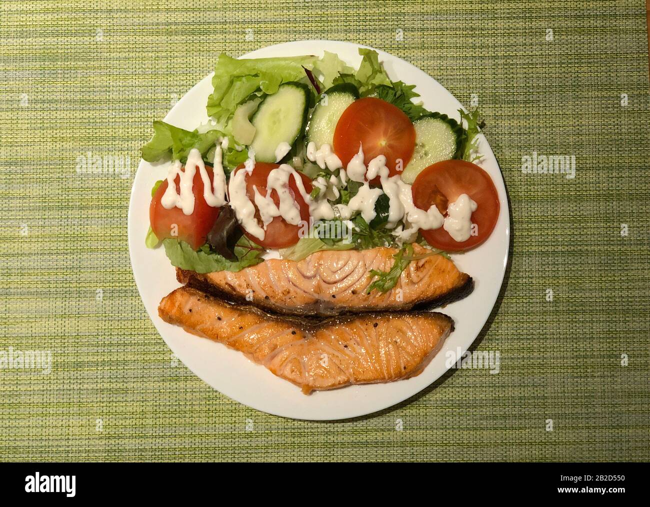 Salmão grelhado com salada de tomate e alface. Prato de restaurante brasileiro. Foto Stock