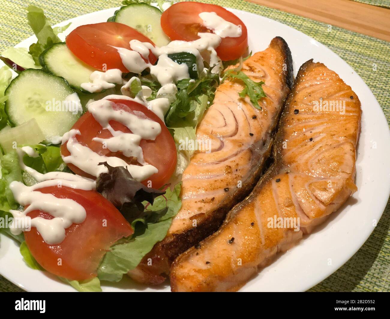 Salmão grelhado com salada de tomate e alface. Prato de restaurante brasileiro. Foto Stock