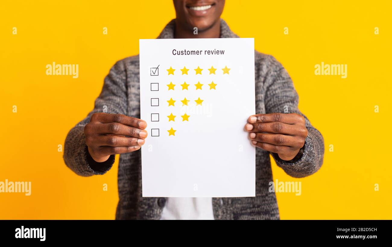 Inriconoscibile uomo africano sfocato che tiene la revisione del cliente Foto Stock