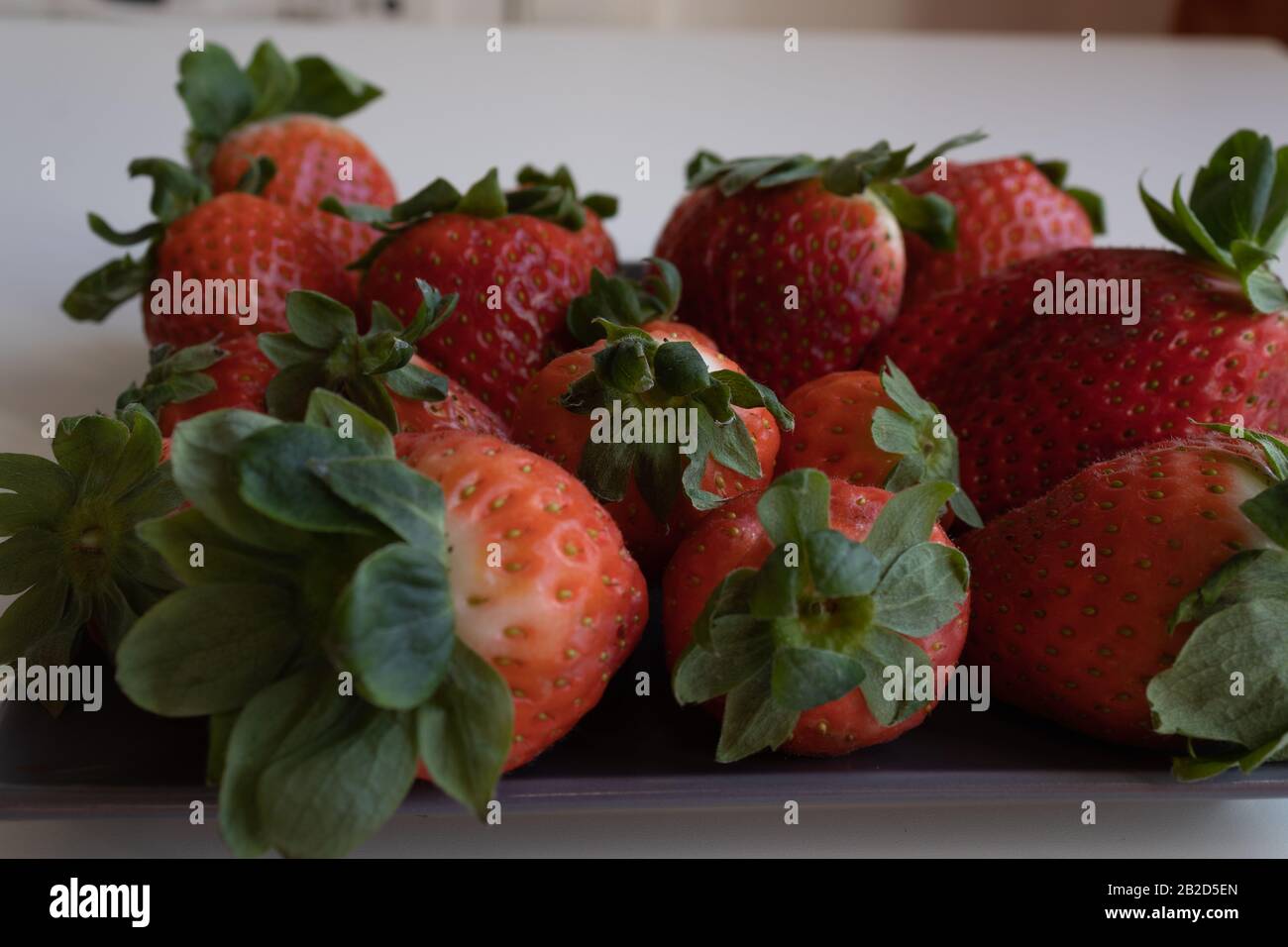 Fragole su lastra di ceramica grigia. Piano orizzontale Foto Stock