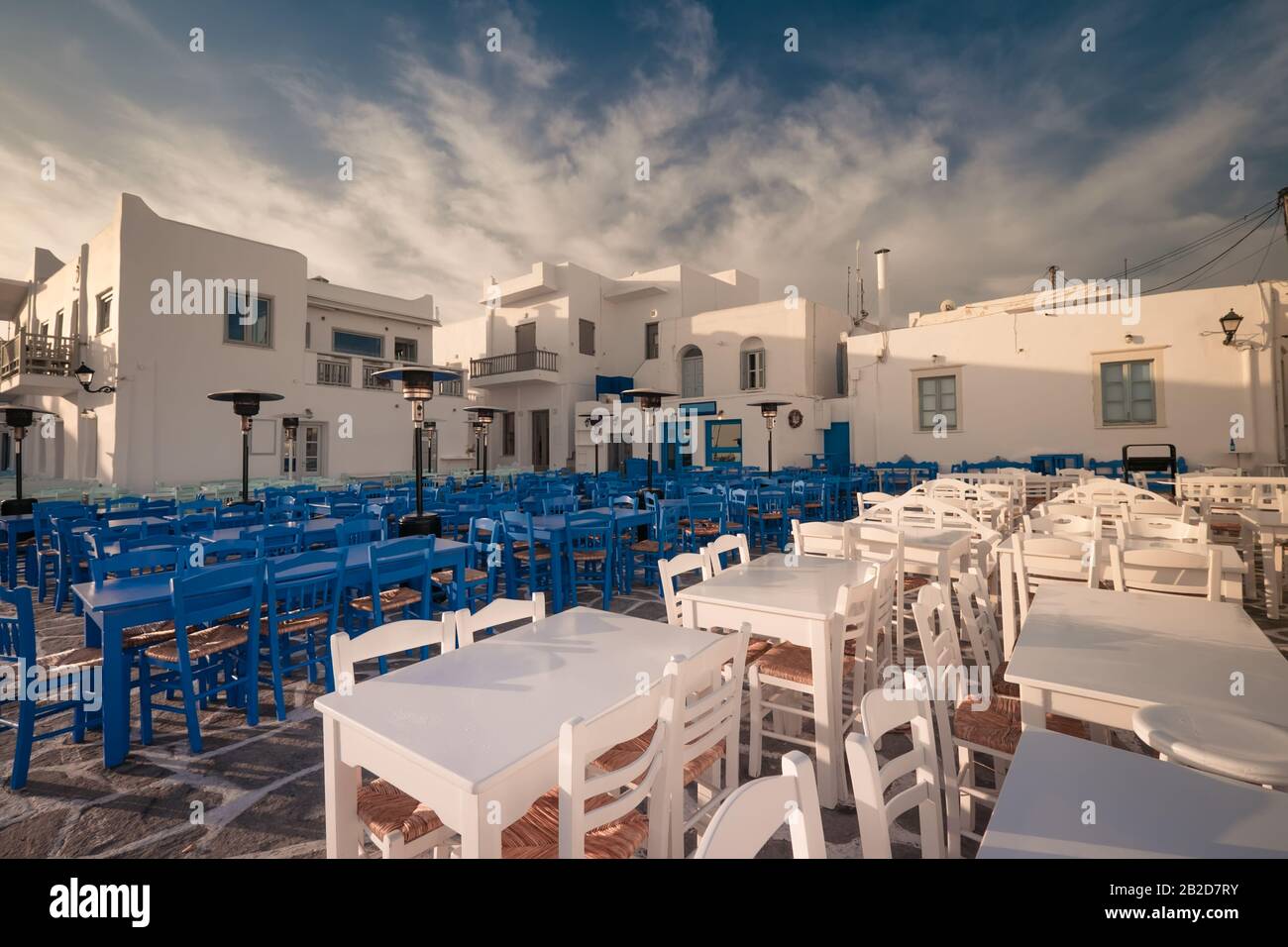 Cafe e ristoranti in una strada stretta incredibile di destinazione popolare sull'isola di Paros. Grecia. Architettura tradizionale e colori del cit mediterraneo Foto Stock