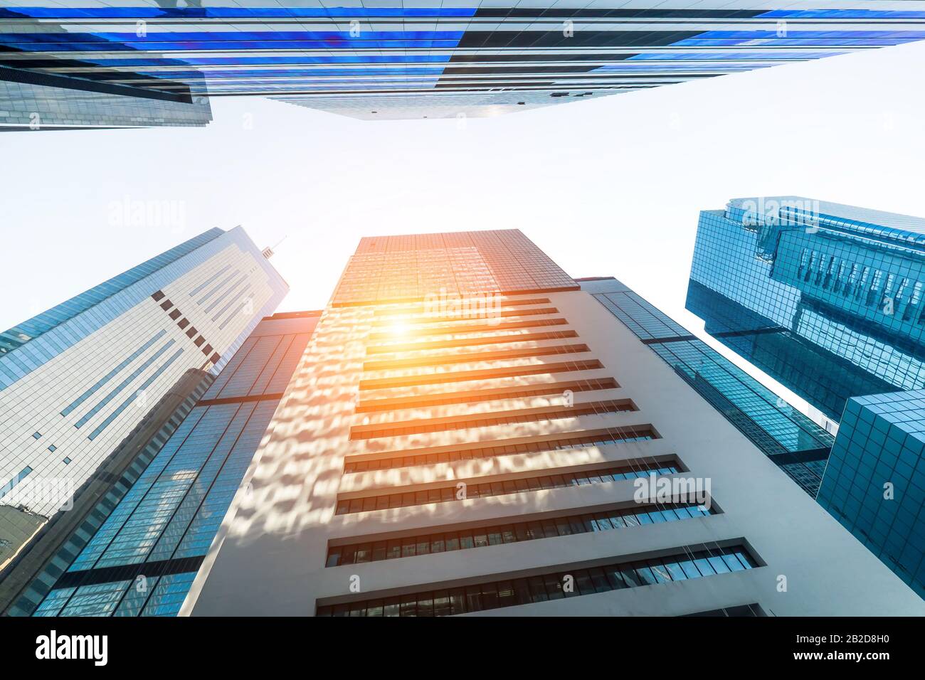 Abstract paesaggio urbano futuristico vista con moderni grattacieli. Sun splende nel cielo di tramonto riflettendo in Windows. Architettura urbana dello sfondo. Hong Kong Foto Stock