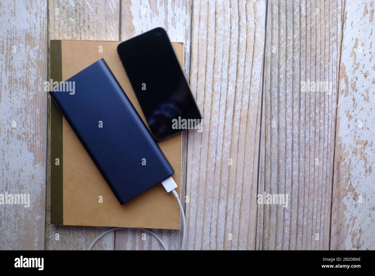 vista dall'alto dello smartphone e del power bank sul tavolo Foto Stock