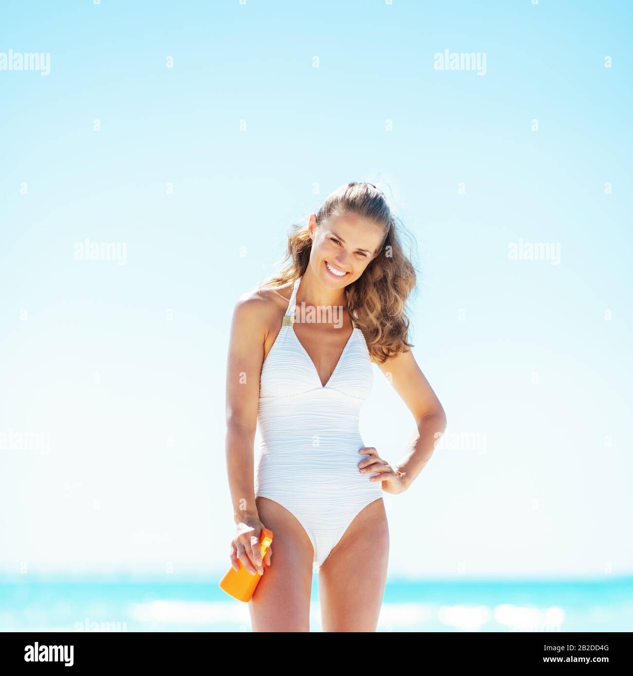 felice giovane donna con crema solare blocco Foto Stock