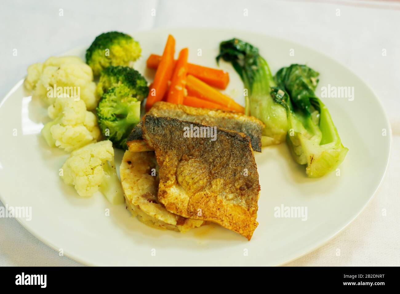 filetto di branzino scottato con purè di patate e verdure al vapore Foto Stock