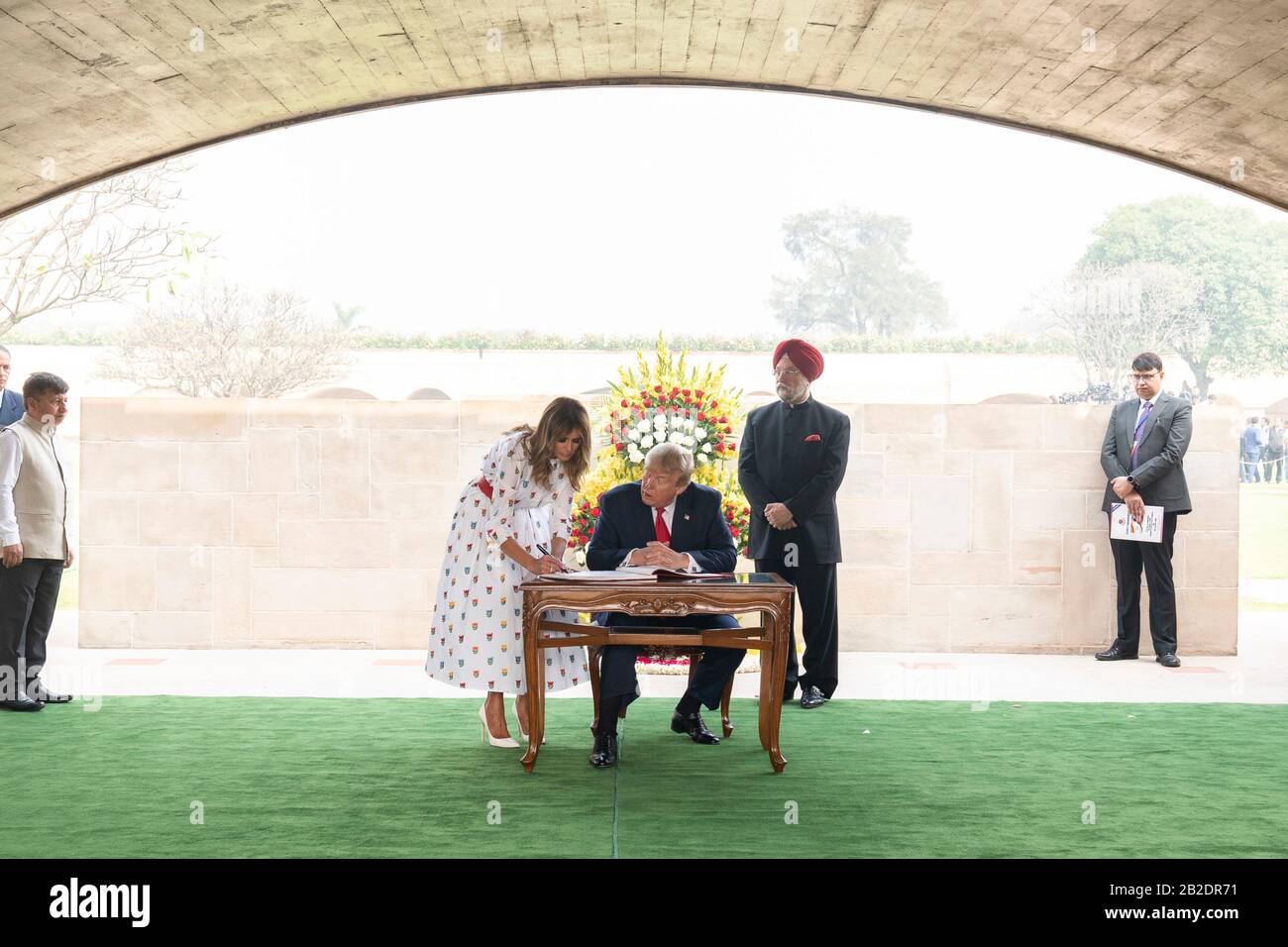 Il presidente degli Stati Uniti Donald Trump e La First Lady Melania Trump firmano il libro degli ospiti al memoriale del Mahatma Gandhi a Raj Ghat il 25 febbraio 2020 a Nuova Delhi, India. Il Ministro indiano per l'aviazione civile, L'Edilizia Abitativa e gli affari urbani Hardeep Singh Puri è a destra. Foto Stock
