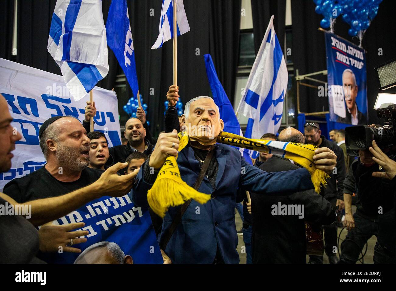 Tel Aviv, Israele. 02nd Mar, 2020. Un sostenitore del partito di Likud che indossa una maschera raffigurante il primo ministro israeliano Benjamin Netanyahu, celebra con gli altri dopo i sondaggi di uscita delle elezioni parlamentari israeliane, presso la sede del partito. Il partito di Likud del primo ministro israeliano Benjamin Netanyahu ha vinto il maggior numero di seggi (36-37) nelle elezioni parlamentari, ma il suo blocco di destra e di partito religioso non ha maggioranza nel parlamento del paese a 120 posti, secondo i sondaggi d'uscita. Credit: Ilia Yefimovic/Dpa/Alamy Live News Foto Stock