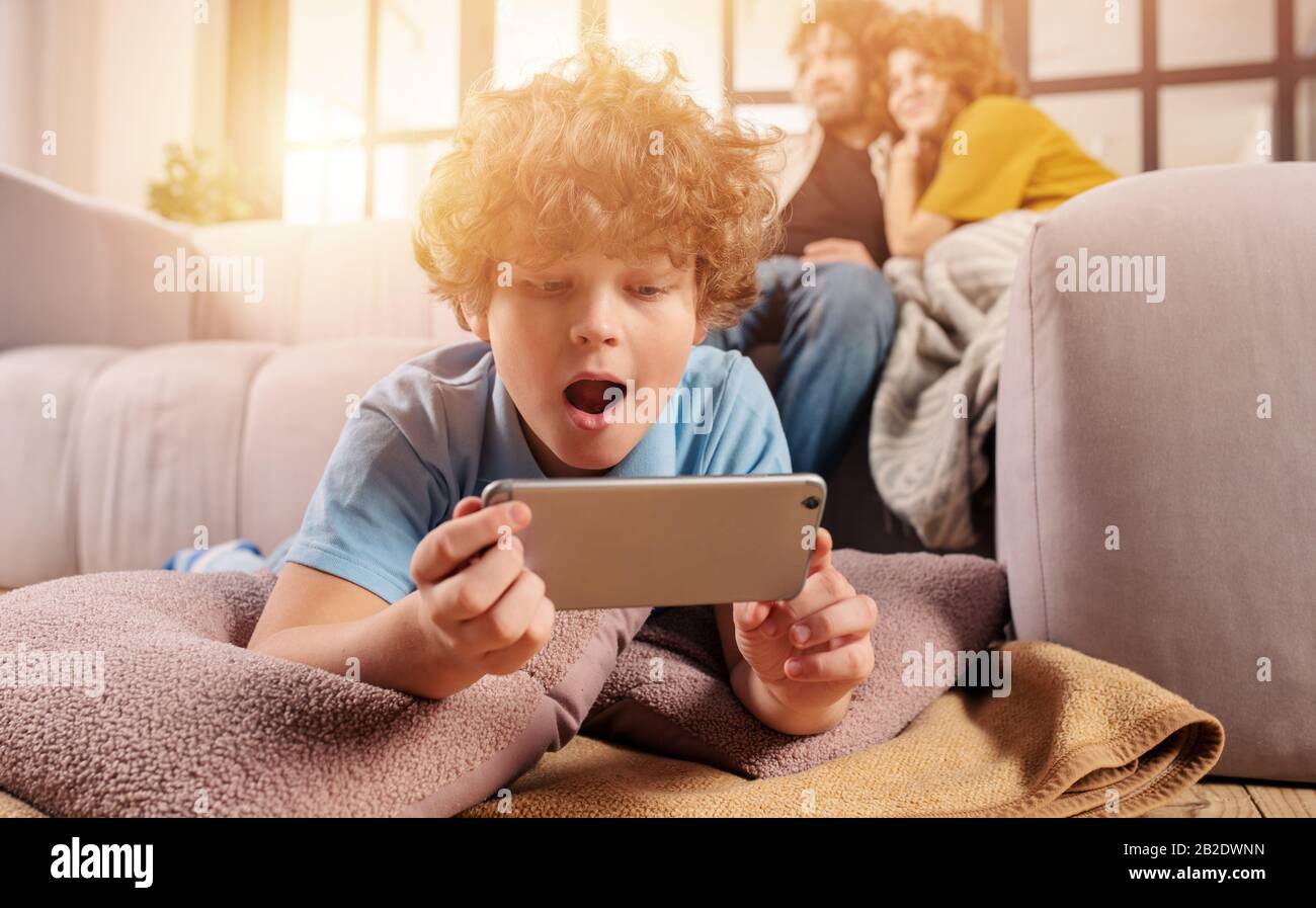 Son gioca online con lo smartphone. Concetto di dipendenza, dipendenza, problema Foto Stock