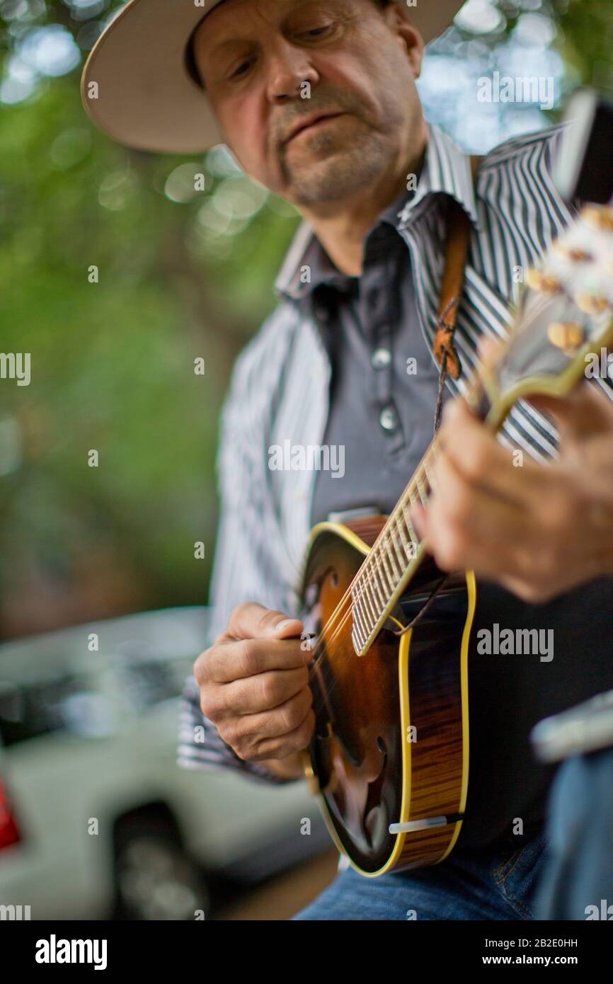 Felice uomo di mezza età che gioca un mandolino Foto Stock