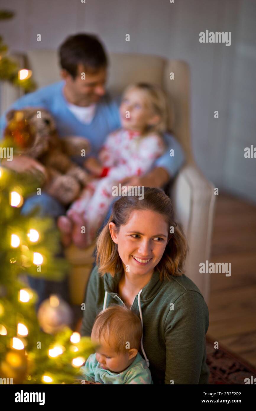 Buona famiglia seduta intorno all'albero di Natale Foto Stock