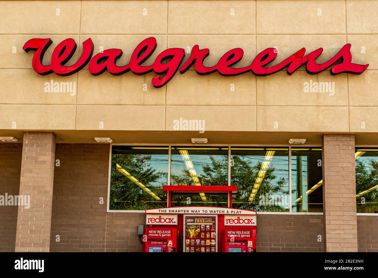 Walgreens Outdoor, marchio della facciata e logo in caratteri rossi su un edificio beige sopra le finestre riflettenti in vetro con film in scatola rossi. Foto Stock