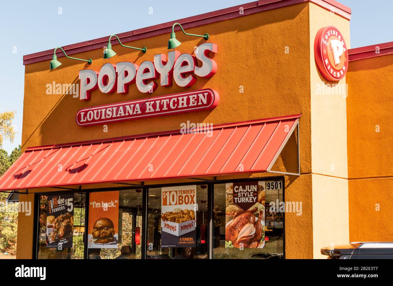 Charlotte, NC/USA - Novenber 9, 2019: Scatto all'aperto medio del marchio 'Popeyes Louisiana Kitchen' rosso e bianco sulla facciata dell'edificio con tenda Foto Stock