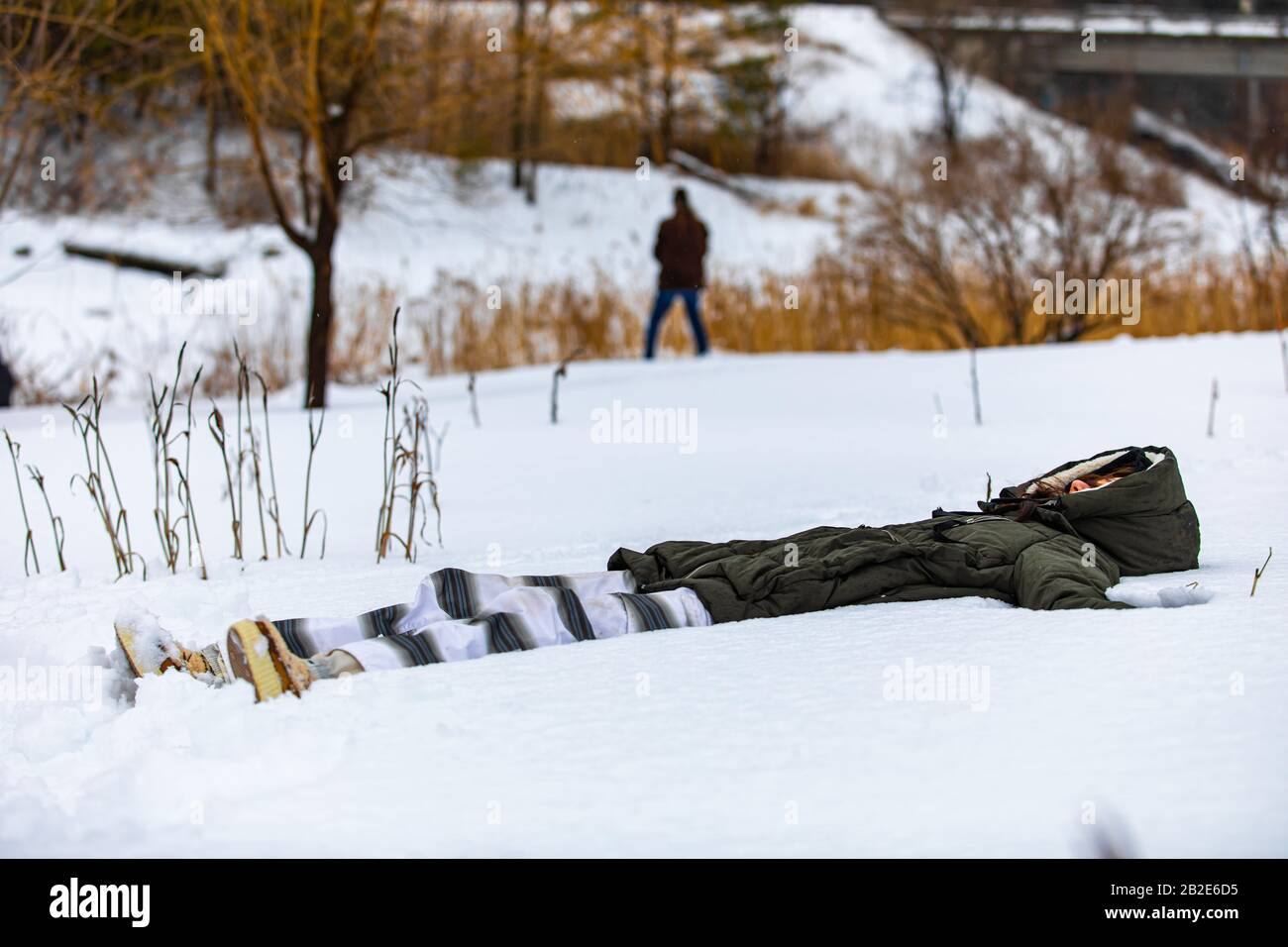 La ragazza che si trova sulla neve e fa un esercizio di yoga. La menzogna nella donna della neve che medita rafforzando il suo legame con la natura Foto Stock
