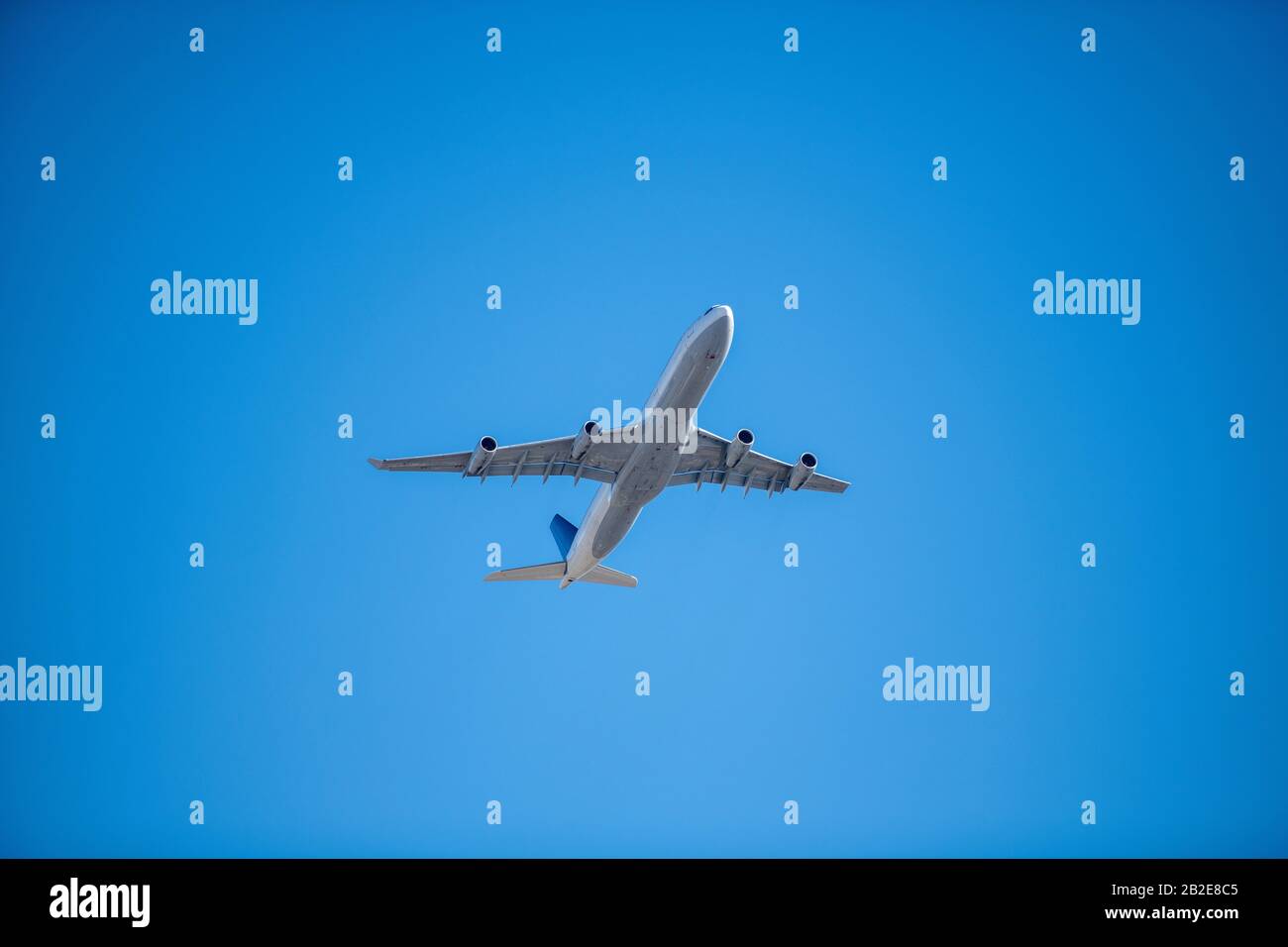 sotto la pancia del passeggero commerciale jet su cielo blu nuvoloso Foto Stock