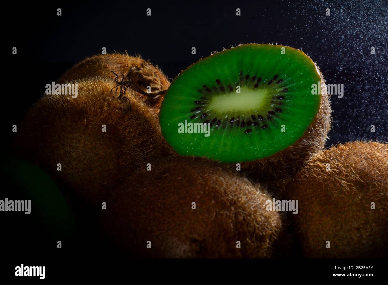 Kiwi con fondo nero e pioggia leggera Foto Stock