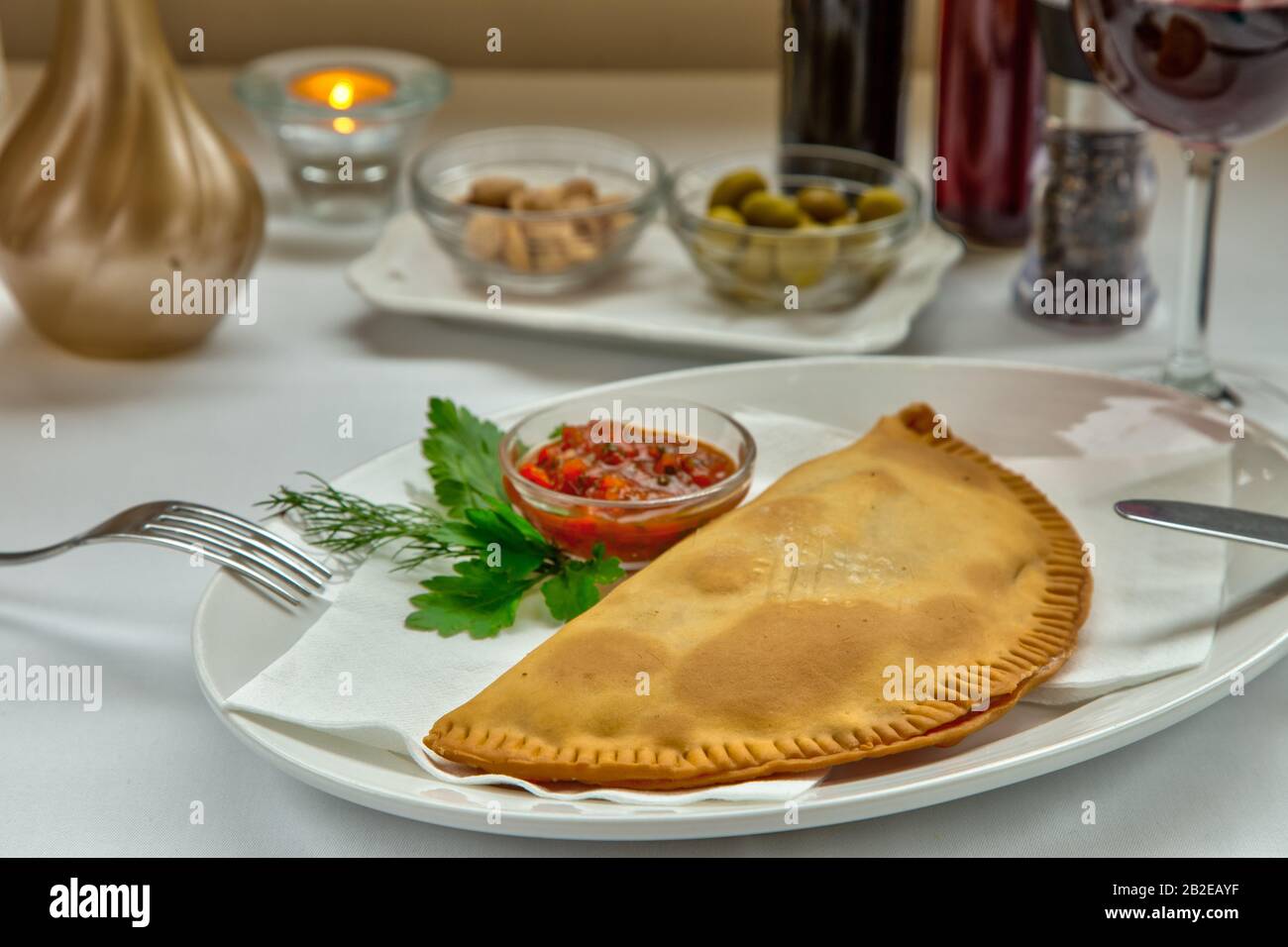 Tradizionale tatar Crimea burette alimentari con carne macinata servita con panna acida su piastra bianca. Foto Stock