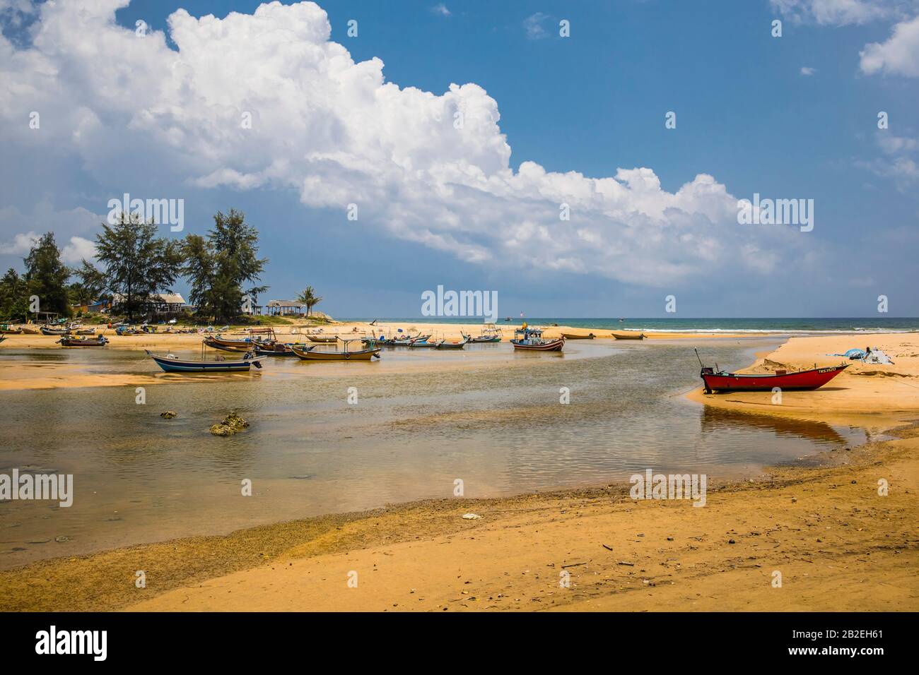 Idilliaco scenario costiero del mare nella costa orientale della Malesia con barche da pesca a ormeggio nel pomeriggio caldo Foto Stock