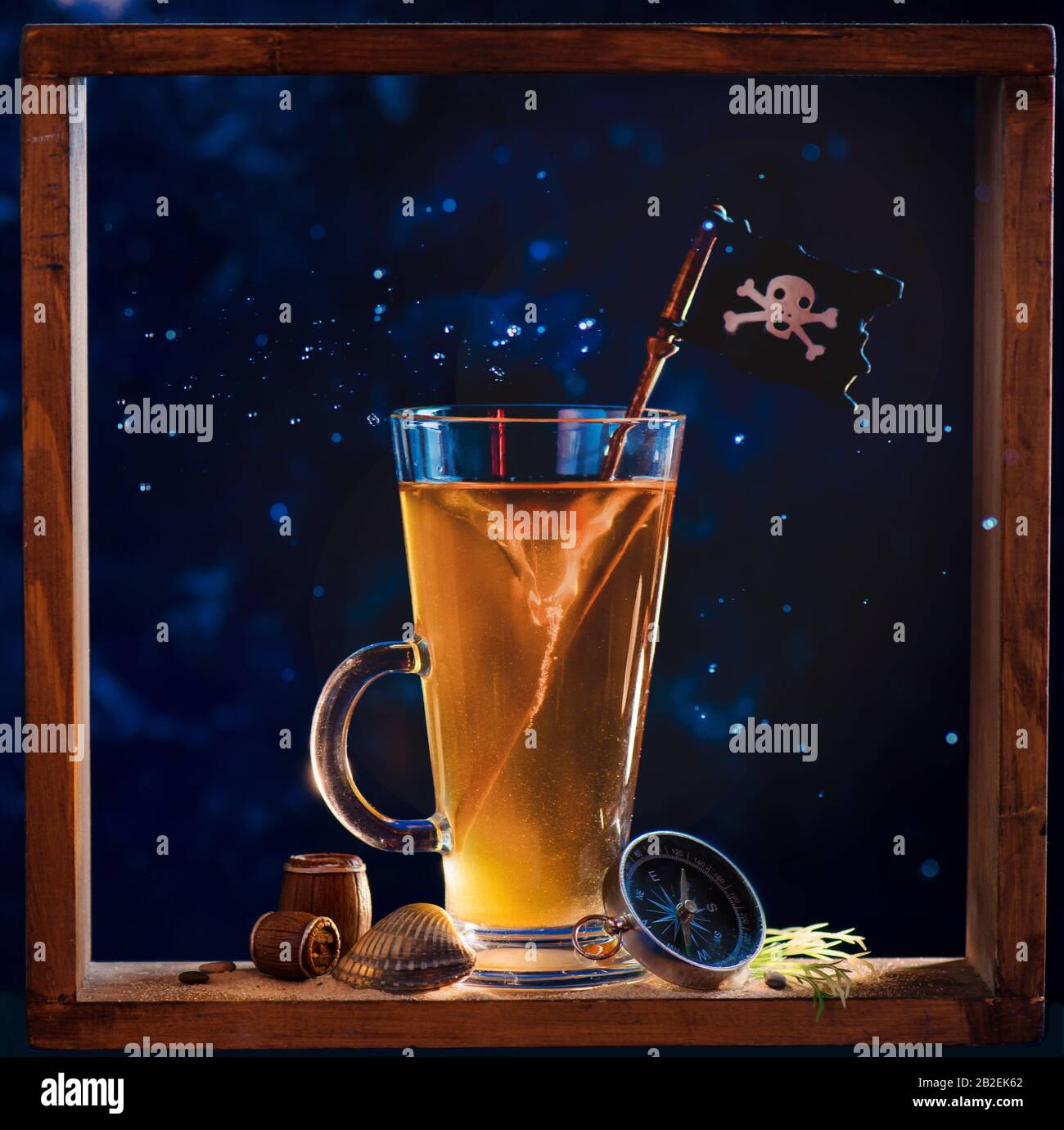 Alto vetro con tè, vorticoso tornado e una bandiera pirata in una cornice in legno, serie bookshelf Foto Stock