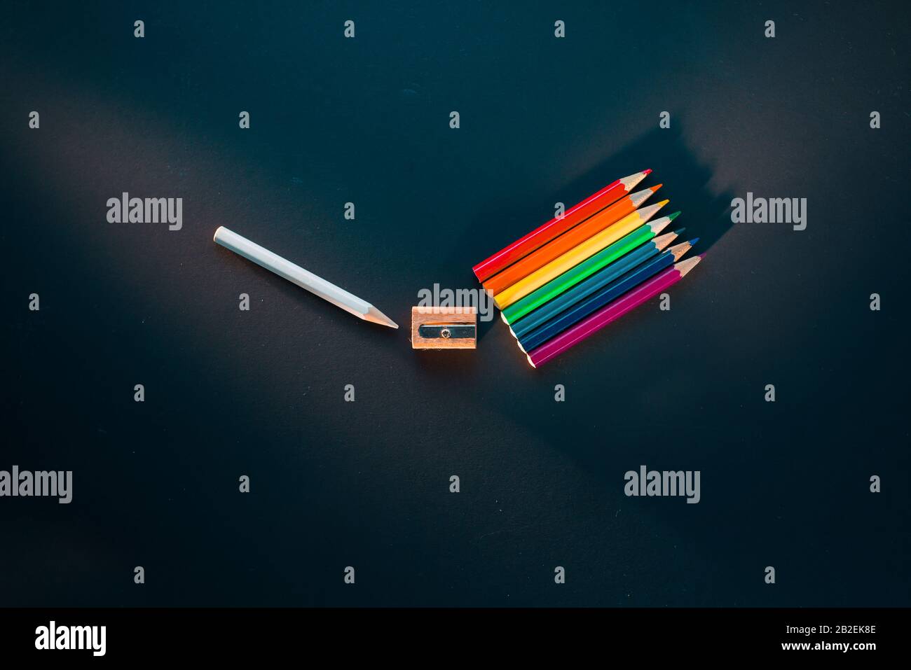 Spettro di luce dalla matita bianca passando attraverso l'affilatura a un arcobaleno di matite, creativo piatto lay Foto Stock