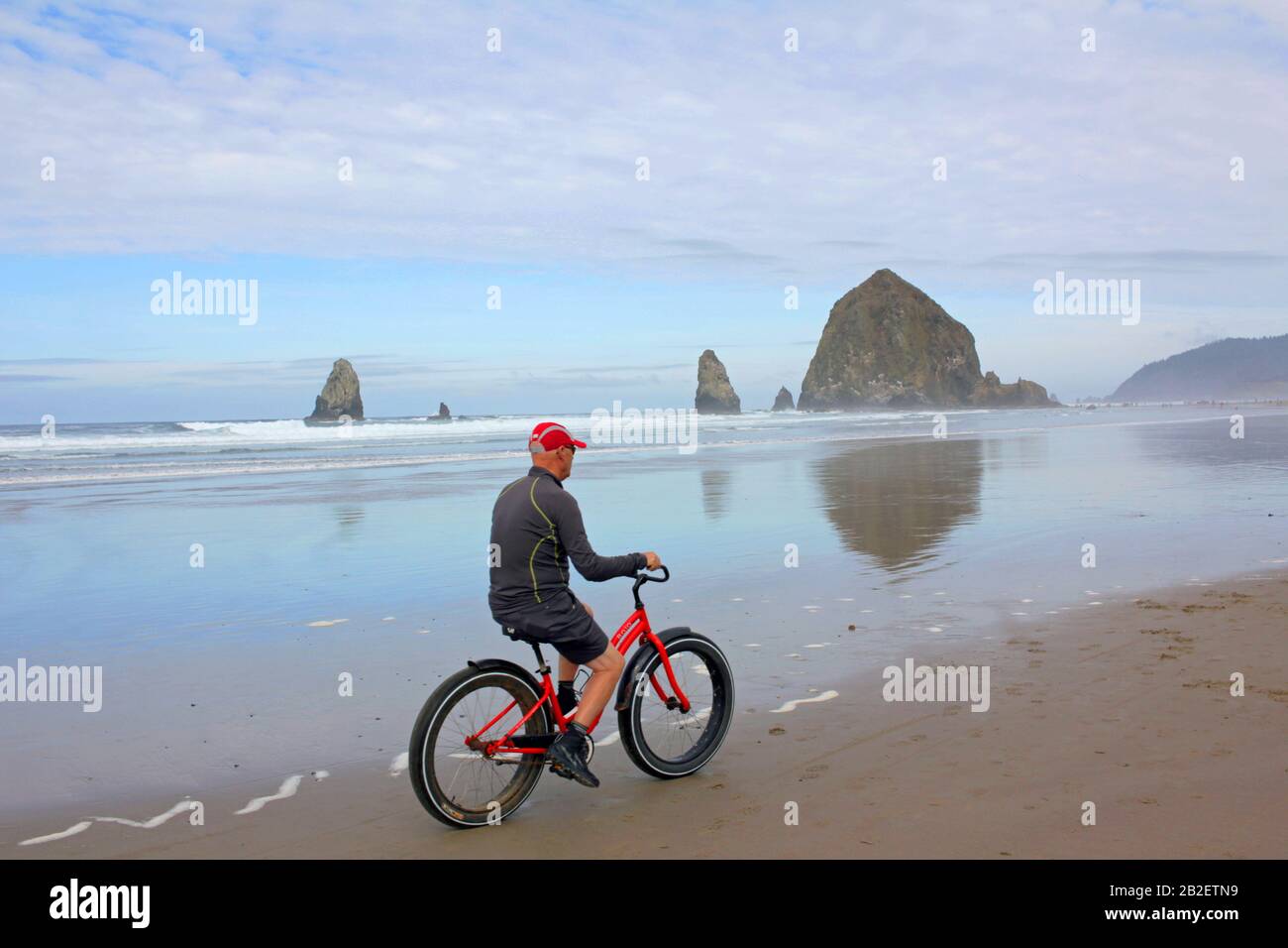 Uomo in bicicletta a Cannon Beach, Oregon, Stati Uniti Foto Stock