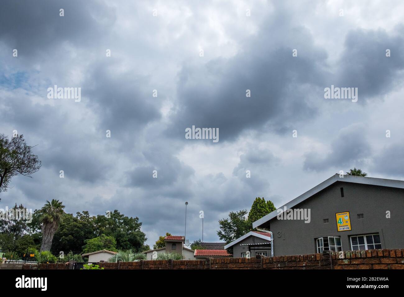 Alberton, Sud Africa - le nubi di tempesta estiva stagionale si raccolgono sopra il sobborgo di immagine di Brackendowns in formato orizzontale Foto Stock