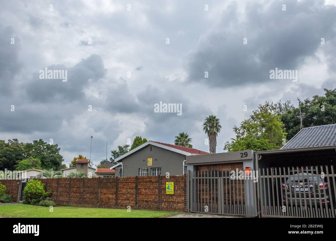 Alberton, Sud Africa - le nubi di tempesta estiva stagionale si raccolgono sopra il sobborgo di immagine di Brackendowns in formato orizzontale Foto Stock