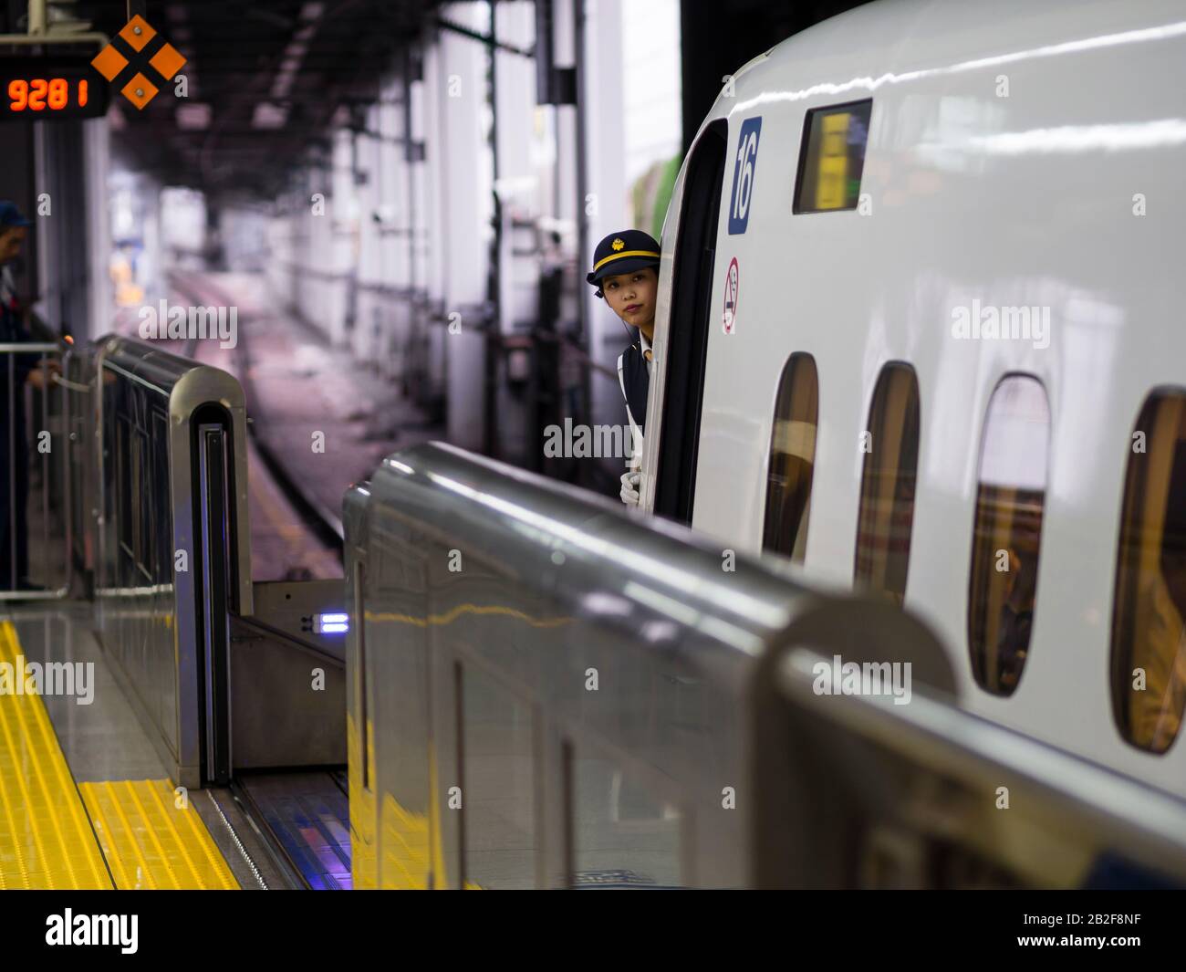 Tokyo, Giappone - 13 ottobre 2018: Il direttore di un treno superveloce della serie N700 Shinkansen sta controllando il binario prima della partenza dalla stazione ferroviaria di Tokyo. Foto Stock
