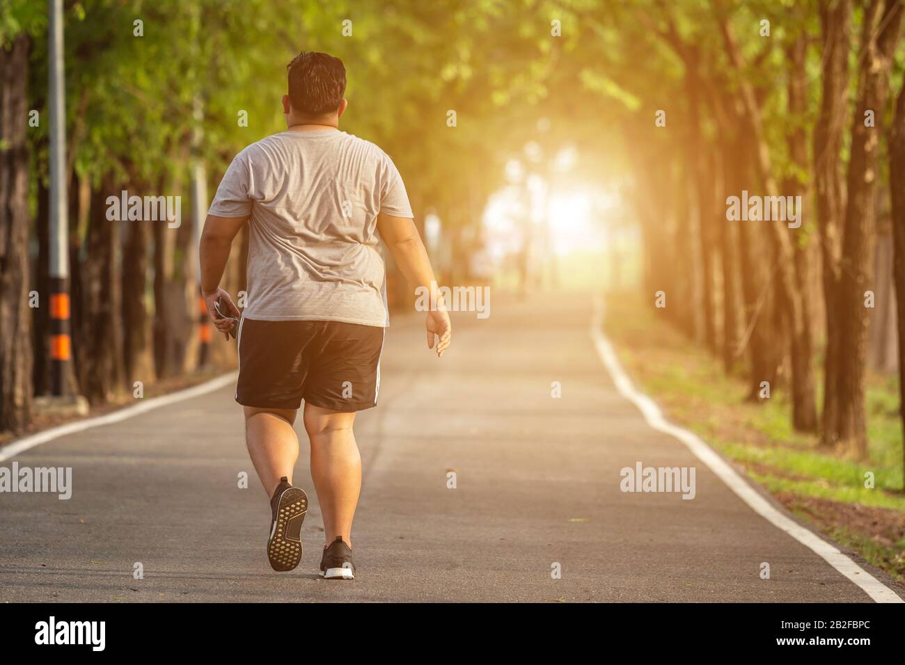 Esercizio e sano concetto: Grasso uomo che corre nel parco Foto Stock