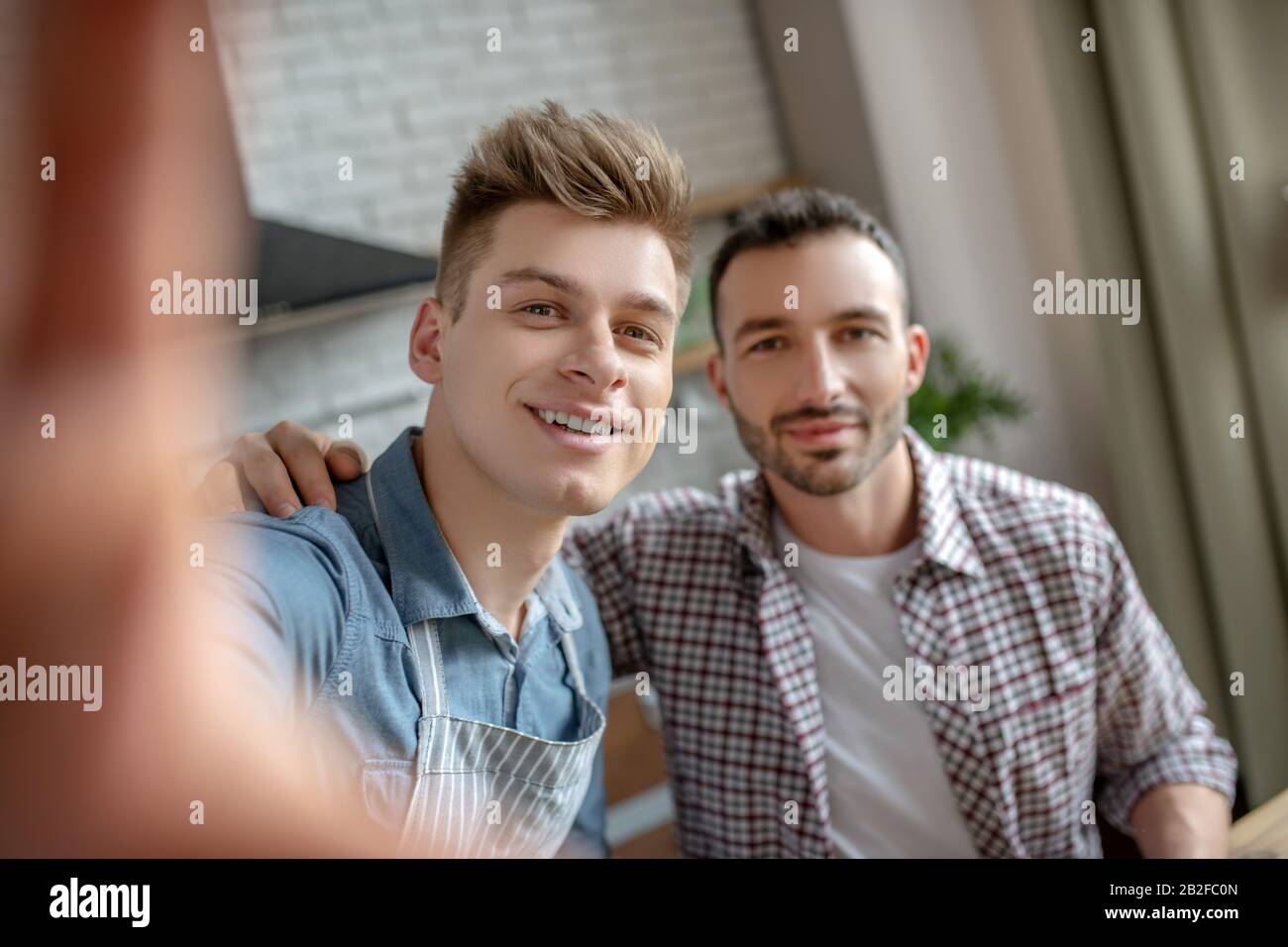 Giovane coppia gay che fa selfie e si sente felice Foto Stock