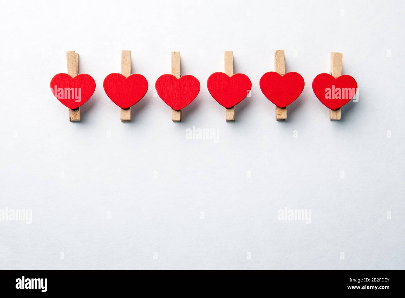 Clip in legno con cuore rosso. Sfondo bianco con spazio di copia. Forniture Per Ufficio Foto Stock