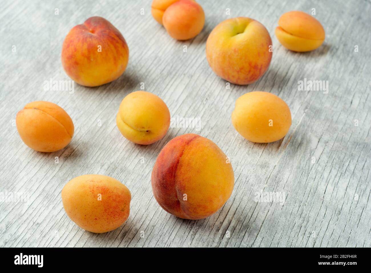 Frutta di pesca dolce e albicocca su tavolo di legno bianco Foto Stock