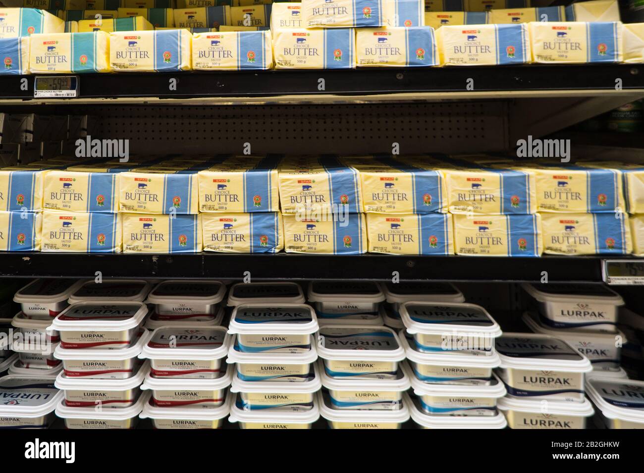 Impacchi, blocchi, mattoni di burro su uno scaffale in un frigorifero aperto in un supermercato, negozio, negozio in Sud Africa Foto Stock