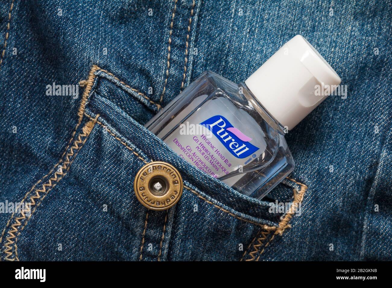 Flacone di strofinamento igienico Purell, gel per le mani, igienizzatore per le mani, in tasca con giacca in denim Red Herring Foto Stock